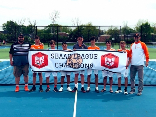 six high school Boys Tennis players standing with three coaches holding a League Champions sign